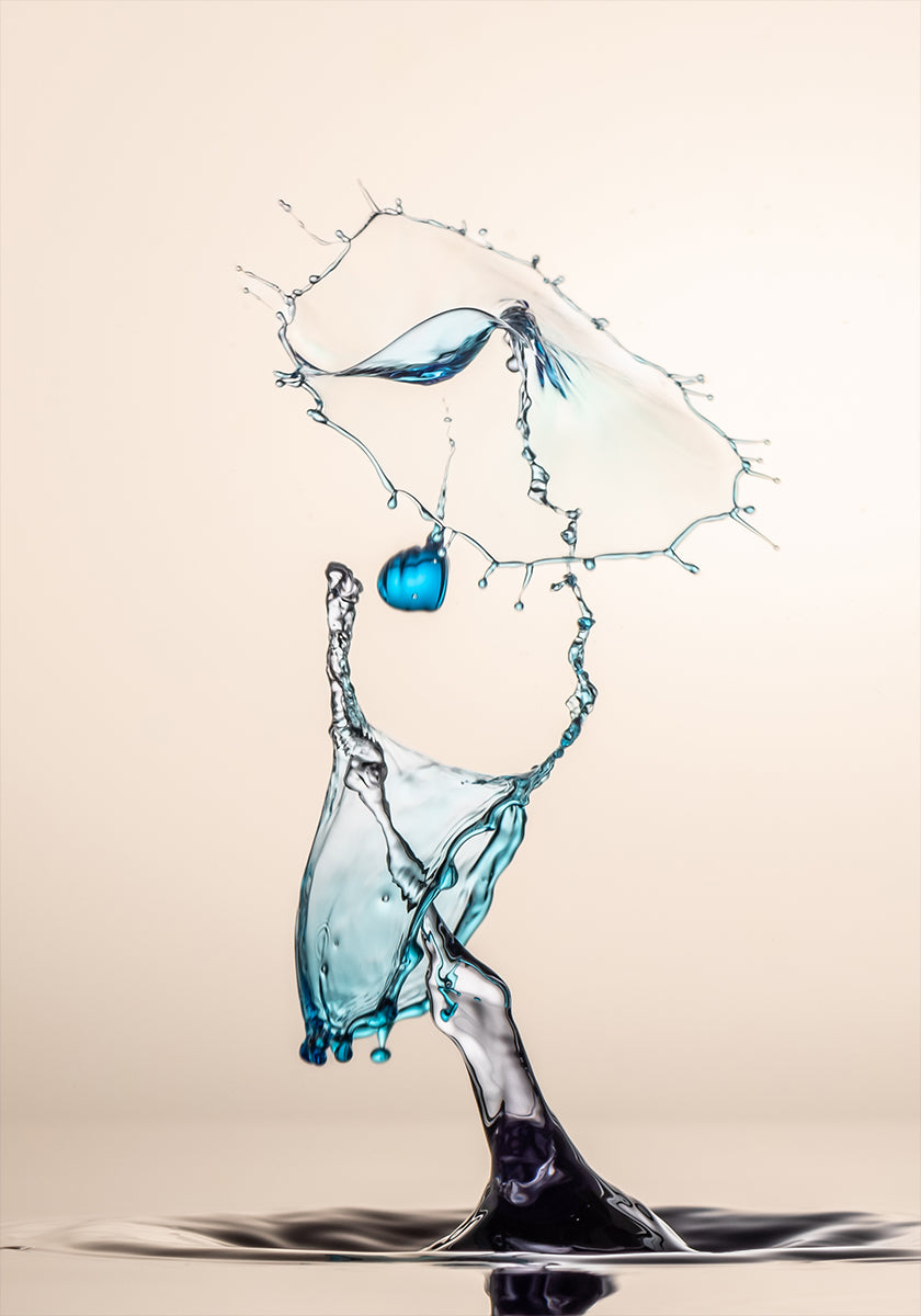 een dynamische waterplons, met een blauw object dat in de lucht hangt en een grote plons water die naar beneden stroomt, waardoor een gevoel van beweging en energie ontstaat.
