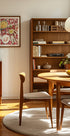 een gezellige eetkamer met een houten tafel en stoelen, een boekenplank en een ingelijst kunstwerk aan de muur.
