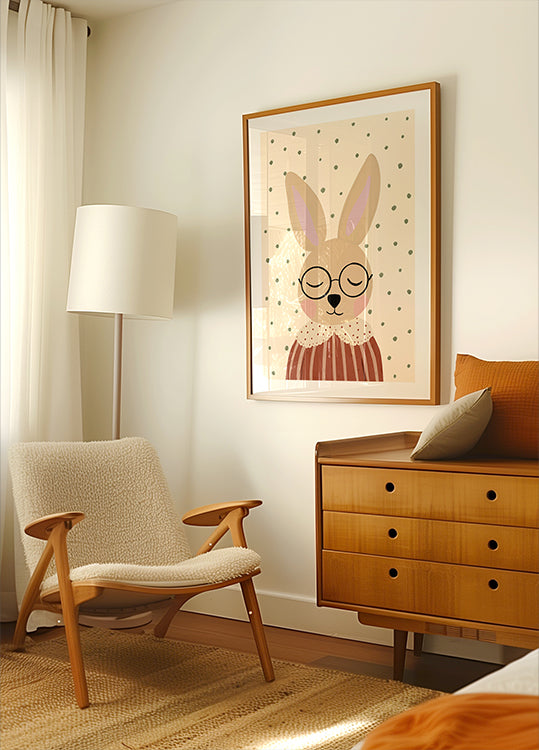 een gezellige woonkamer met een beige fauteuil, een houten ladekast en een ingelijste foto van een konijn met een bril.